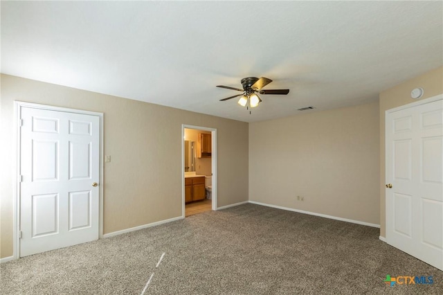 unfurnished bedroom featuring carpet flooring, ceiling fan, and ensuite bathroom