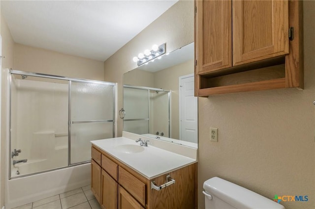 full bathroom with tile patterned flooring, vanity, bath / shower combo with glass door, and toilet