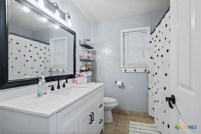 full bath featuring vanity, tile patterned flooring, and toilet