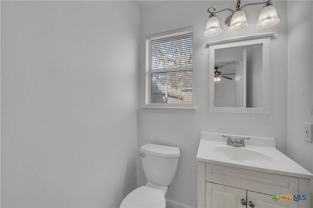 bathroom with vanity, toilet, and ceiling fan with notable chandelier