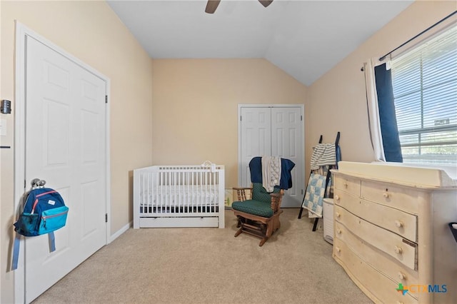 bedroom featuring lofted ceiling, light carpet, a closet, and ceiling fan