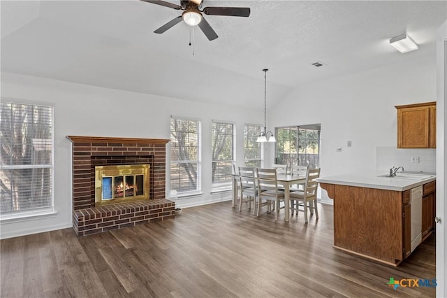 interior space with lofted ceiling, dark hardwood / wood-style floors, a textured ceiling, and a brick fireplace