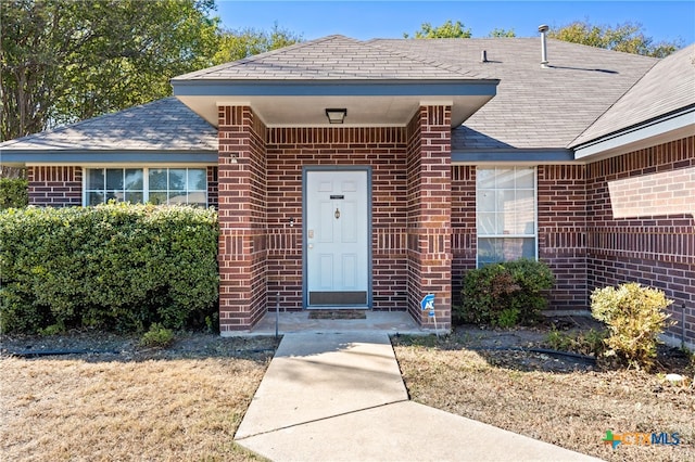 view of exterior entry with a lawn