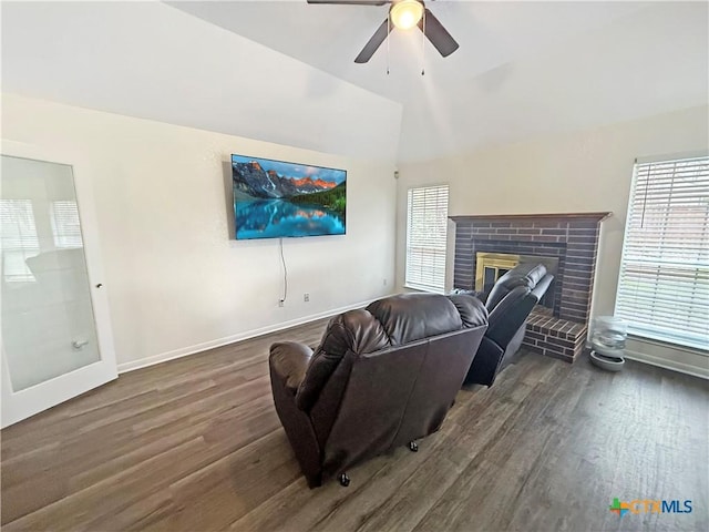 living room featuring ceiling fan, lofted ceiling, dark hardwood / wood-style flooring, and a brick fireplace