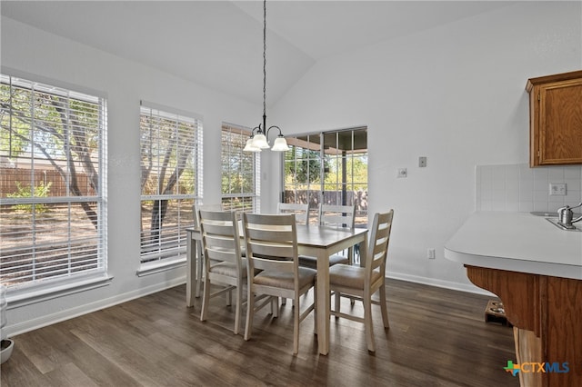 dining space featuring lofted ceiling, dark hardwood / wood-style flooring, and a notable chandelier