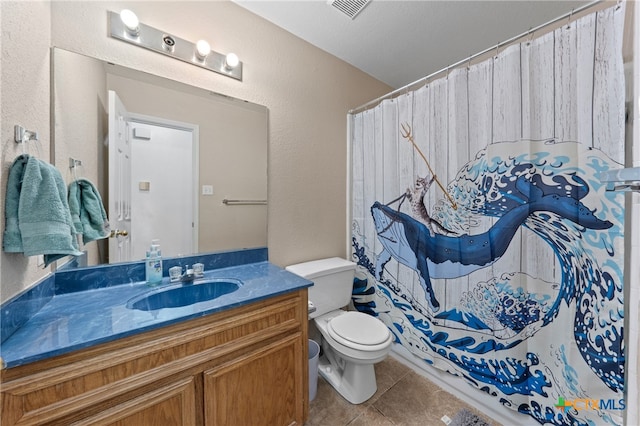 bathroom with tile patterned flooring, vanity, and toilet