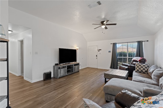 living room featuring ceiling fan, lofted ceiling, wood-type flooring, and a textured ceiling