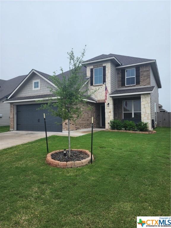 view of front of property with a garage and a front lawn