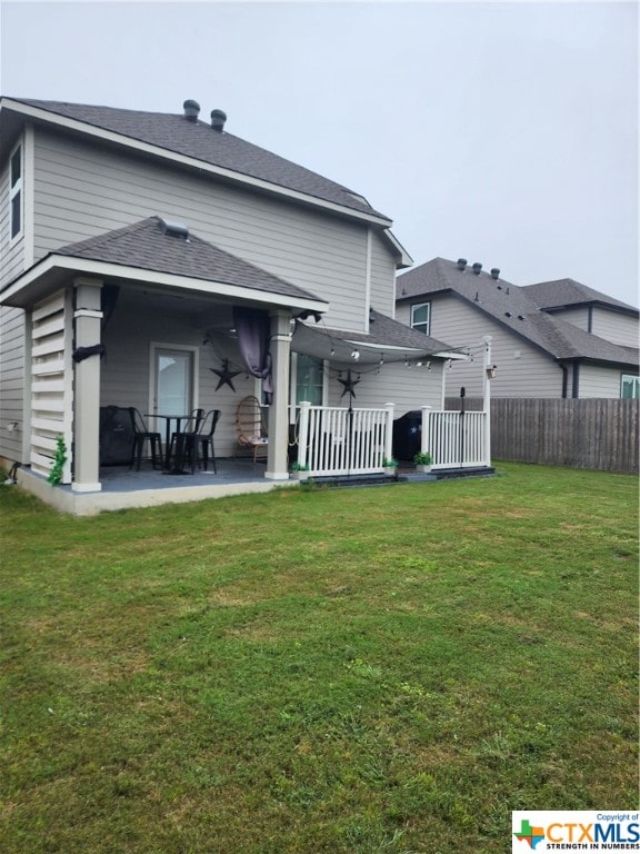 rear view of house with a patio area, ceiling fan, and a yard