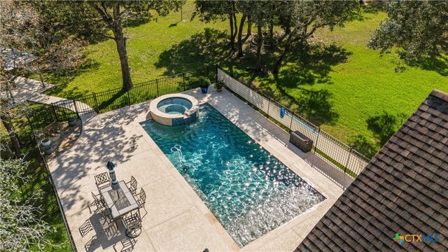 view of pool with a pool with connected hot tub, a patio area, and fence