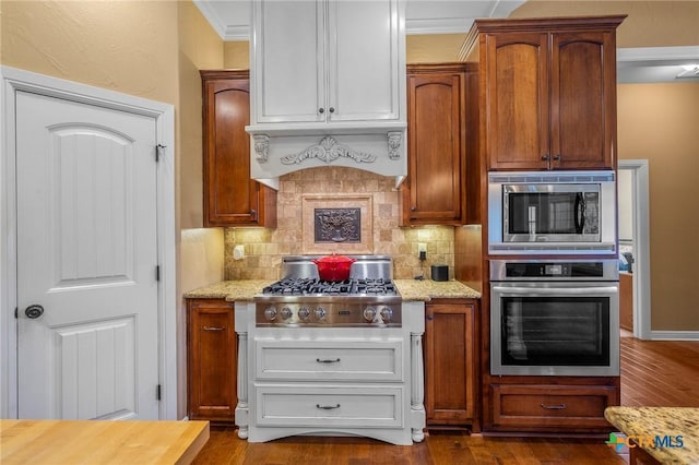 55 Post Oak Bnd, Inez, TX 77968 - kitchen featuring stainless steel appliances, tasteful backsplash, light stone countertops, dark wood-style flooring, and ornamental molding