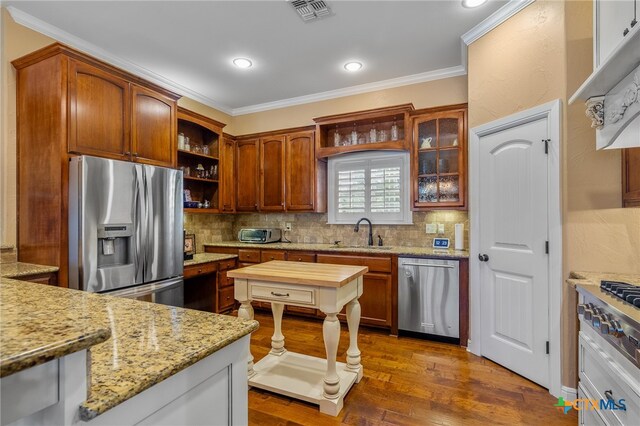 kitchen featuring visible vents, stainless steel appliances, a sink, and ornamental molding