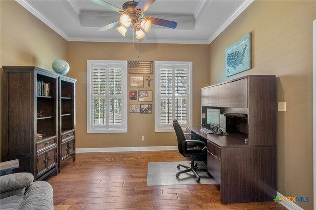 office featuring a ceiling fan, crown molding, baseboards, and hardwood / wood-style floors