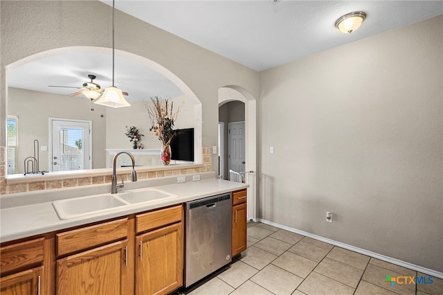 kitchen with stainless steel dishwasher, a sink, ceiling fan, light countertops, and light tile patterned floors