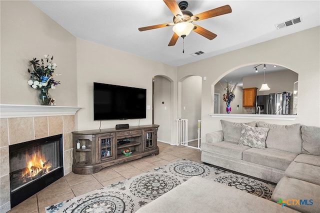 living area featuring visible vents, a fireplace, and tile patterned floors