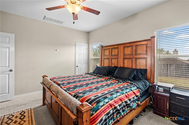 bedroom featuring a ceiling fan, light colored carpet, visible vents, and baseboards