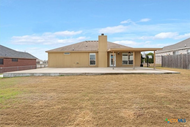 rear view of house with a patio area and a lawn