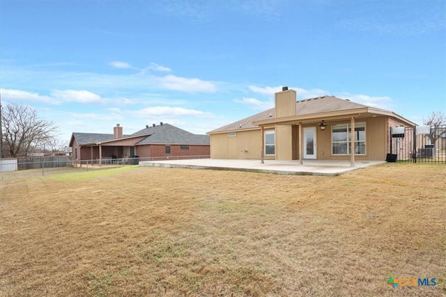 rear view of property featuring a yard and a patio area