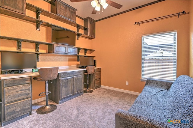 office featuring baseboards, carpet, ceiling fan, and built in desk