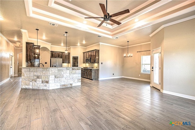 kitchen featuring visible vents, dark brown cabinets, a tray ceiling, ceiling fan with notable chandelier, and appliances with stainless steel finishes