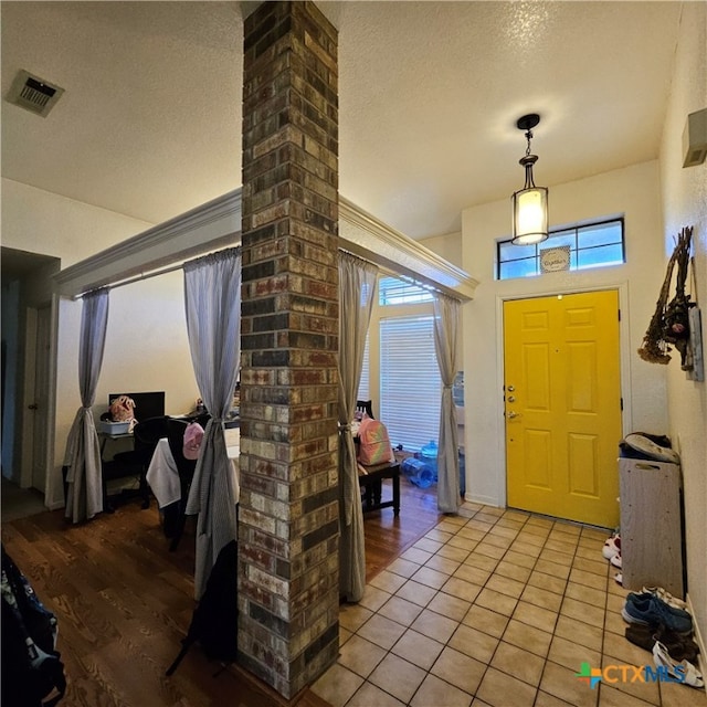 tiled entryway with a textured ceiling