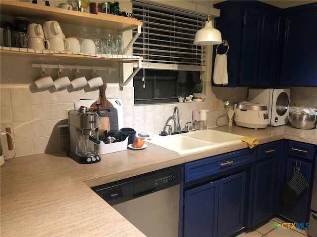 kitchen featuring pendant lighting, sink, stainless steel dishwasher, blue cabinetry, and tasteful backsplash