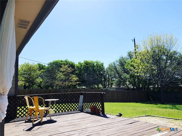 wooden deck featuring a lawn