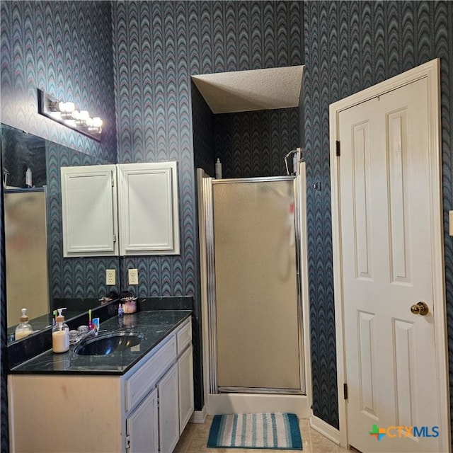 bathroom featuring tile patterned flooring, vanity, and a shower with door