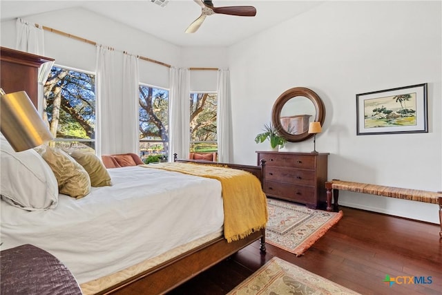 bedroom featuring dark hardwood / wood-style flooring, vaulted ceiling, and ceiling fan