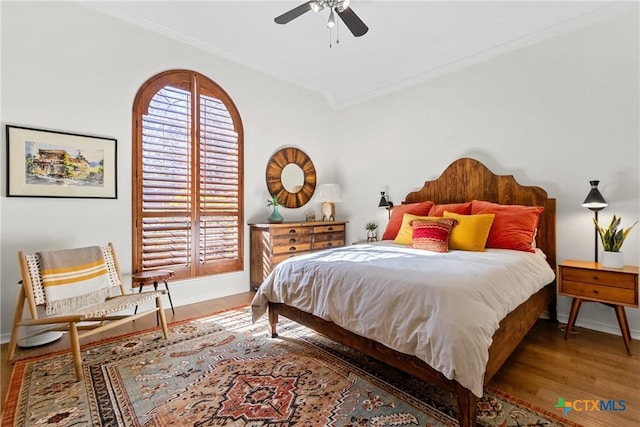 bedroom featuring multiple windows, hardwood / wood-style floors, and crown molding