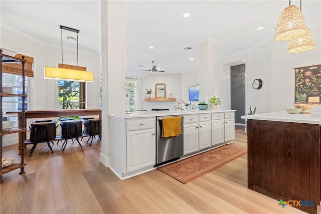 kitchen featuring pendant lighting, stainless steel dishwasher, light hardwood / wood-style floors, and white cabinets