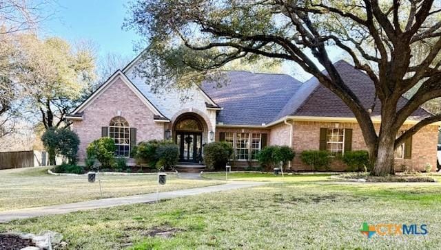 view of front of house featuring a front yard and french doors