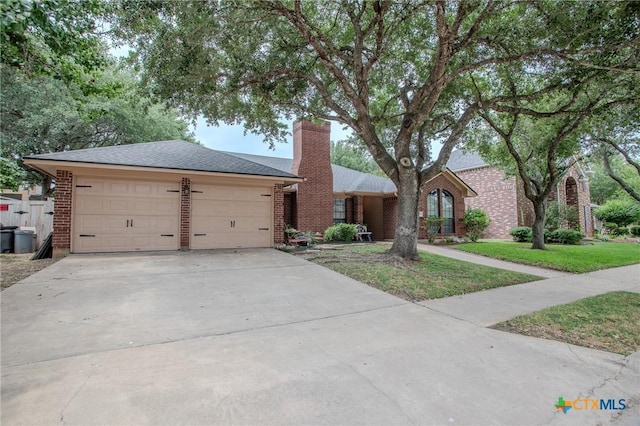 113 Ashford Dr, Victoria, TX 77904 - ranch-style house featuring a chimney, driveway, brick siding, a front lawn, and an attached garage