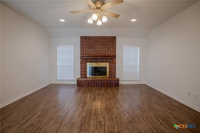 113 Ashford Dr, Victoria, TX 77904 - unfurnished living room with vaulted ceiling, wood finished floors, baseboards, a fireplace, and a ceiling fan