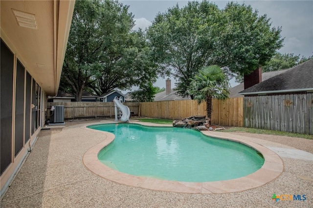 113 Ashford Dr, Victoria, TX 77904 - view of swimming pool featuring a water slide, a fenced backyard, and central air condition unit