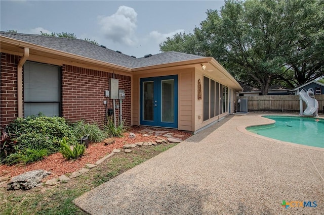 113 Ashford Dr, Victoria, TX 77904 - view of swimming pool with a water slide, central air condition unit, and a patio