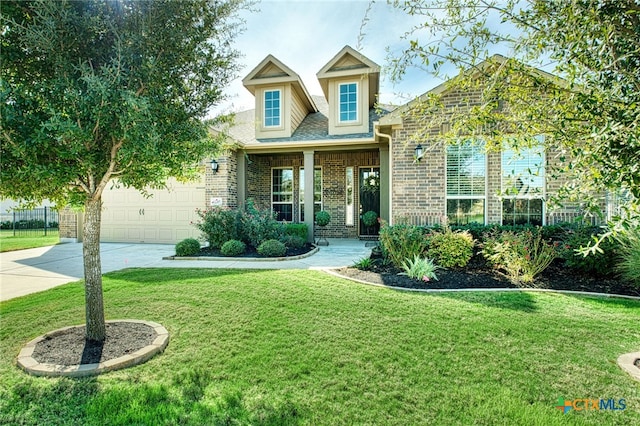 cape cod home featuring a garage and a front yard