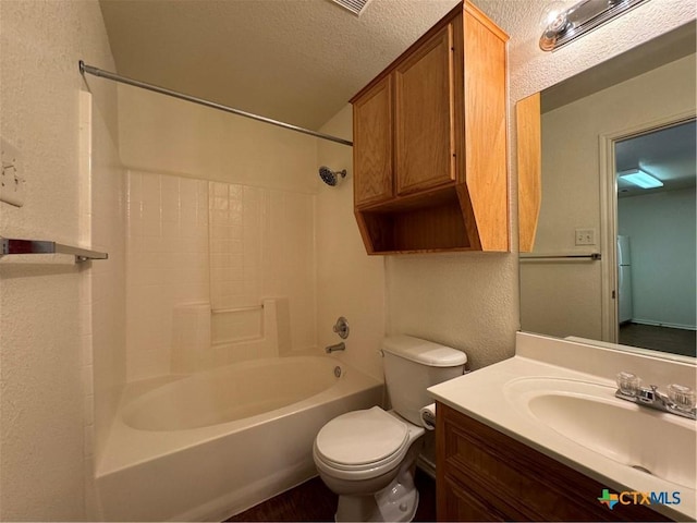 full bath with toilet, a textured wall, tub / shower combination, a textured ceiling, and vanity