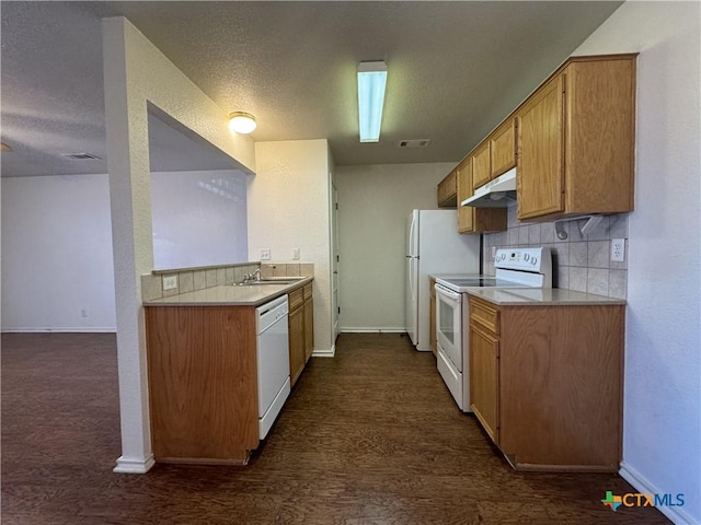kitchen featuring visible vents, baseboards, white appliances, and under cabinet range hood