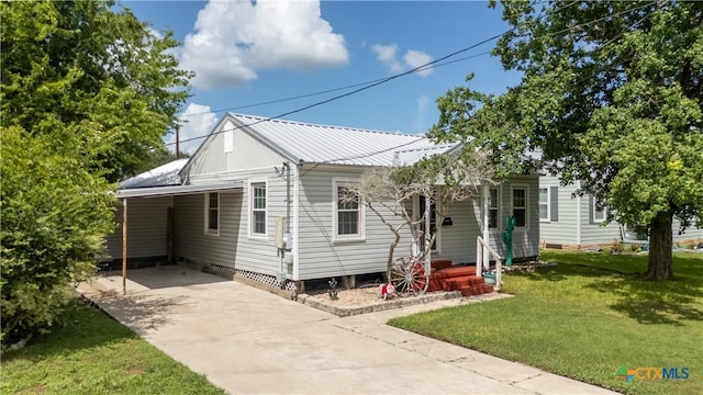 516 2nd St, Cuero, TX 77954 - view of front of property with driveway, a carport, a front lawn, and a metal roof
