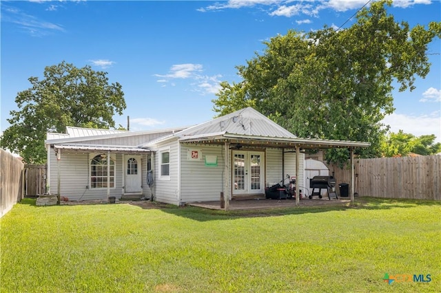 516 2nd St, Cuero, TX 77954 - back of house with french doors, a fenced backyard, a shed, and a metal roof