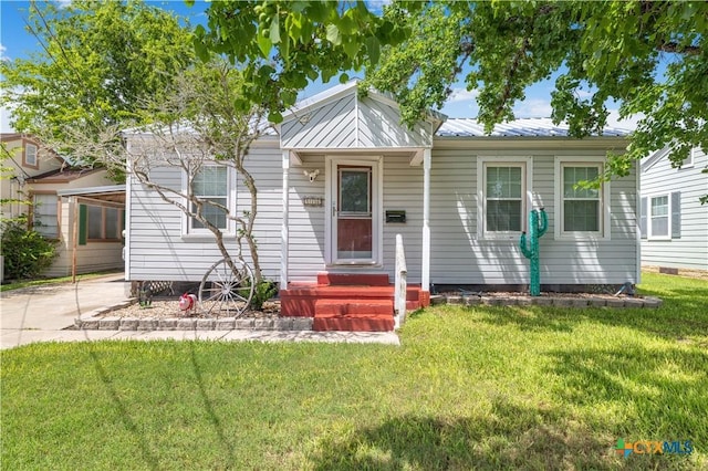 516 2nd St, Cuero, TX 77954 - bungalow with a front yard, a metal roof, and driveway