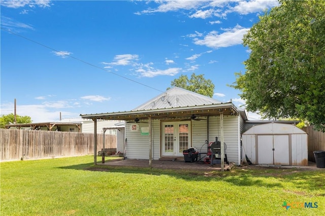 516 2nd St, Cuero, TX 77954 - back of house featuring french doors, a fenced backyard, a storage shed, a patio, and a ceiling fan