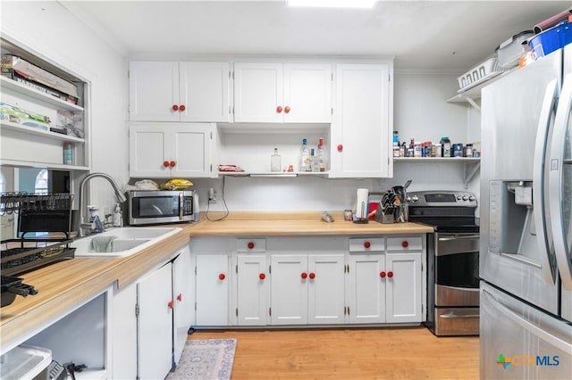 516 2nd St, Cuero, TX 77954 - kitchen with open shelves, stainless steel appliances, white cabinetry, light countertops, and ornamental molding