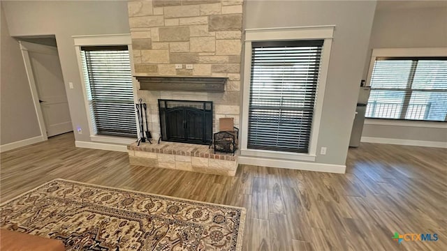1026 County Road 3152, Kempner, TX 76539 - unfurnished living room with a large fireplace, baseboards, wood finished floors, and healthy amount of natural light