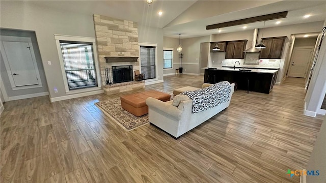 1026 County Road 3152, Kempner, TX 76539 - living room featuring vaulted ceiling, baseboards, light wood-style flooring, a fireplace, and recessed lighting