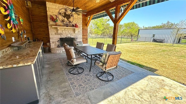 1026 County Road 3152, Kempner, TX 76539 - view of patio / terrace featuring an outdoor stone fireplace, a ceiling fan, exterior kitchen, and outdoor dining space