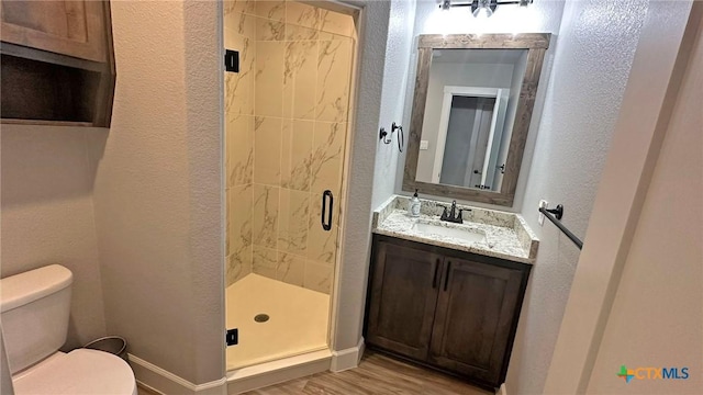 1026 County Road 3152, Kempner, TX 76539 - bathroom featuring a stall shower, toilet, a textured wall, vanity, and wood finished floors