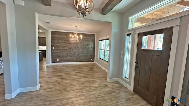 1026 County Road 3152, Kempner, TX 76539 - entryway with a chandelier, baseboards, light wood-style floors, wood walls, and an accent wall