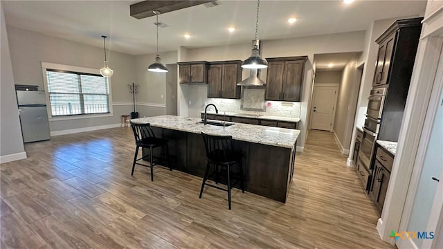 1026 County Road 3152, Kempner, TX 76539 - kitchen featuring a sink, appliances with stainless steel finishes, baseboards, backsplash, and light wood-type flooring